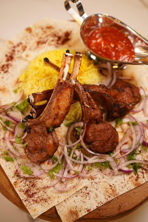 Grilled lamb chops on lavash with saffron rice, red onion, herbs and red sauce